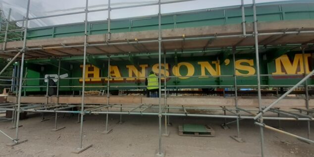 A signwriter is currently putting the finishing touches to the new bridge in the iconic green and yellow brand colours of Hanson's Ale.